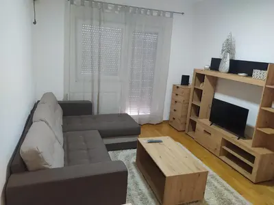 a living room with a couch and a television at Relax, apartman sa garažnim mestom in Obrenovac