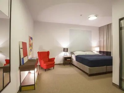 a hotel room with a bed and a red chair at Savamala b&b in Belgrade
