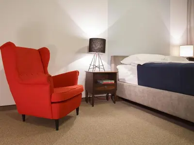 a bedroom with a red chair and a bed at Savamala b&b in Belgrade