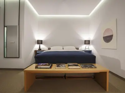 a bedroom with a bed and a table with books at Savamala b&b in Belgrade