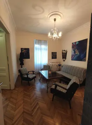 a living room with a table and chairs and a chandelier at Skorpion in Belgrade