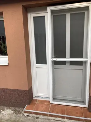 a pair of doors on the side of a house at House Apartment in Pančevo