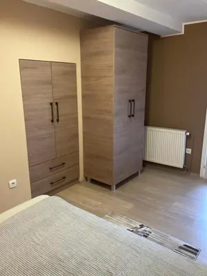a bedroom with two wooden cabinets and a bed at House Apartment in Pančevo