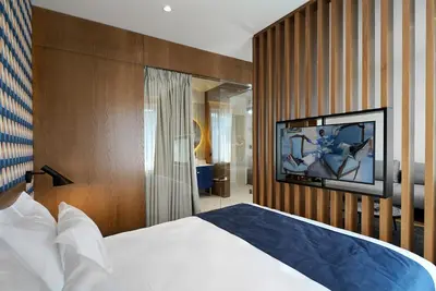 a bedroom with a bed and a tv on a wall at Dominic Smart & Luxury Suites - Edition in Belgrade