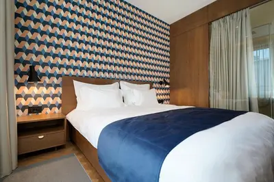 a bedroom with a large bed with a blue blanket at Dominic Smart & Luxury Suites - Edition in Belgrade