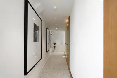 a hallway with white walls and pictures on the walls at Dominic Smart & Luxury Suites - Edition in Belgrade