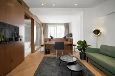 a living room with a green couch and a desk at Dominic Smart & Luxury Suites - Edition in Belgrade