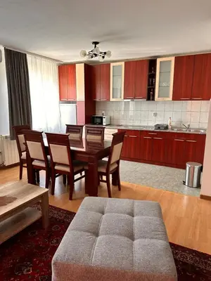 a living room with a table and chairs and a kitchen at Helena apartment in Belgrade