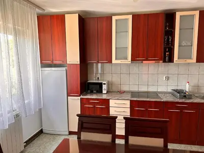 a kitchen with wooden cabinets and a white refrigerator at Helena apartment in Belgrade