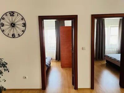 a room with a clock on the wall and a bedroom at Helena apartment in Belgrade
