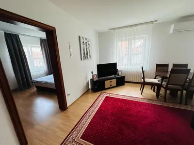 a living room with a red rug and a dining room at Helena apartment in Belgrade