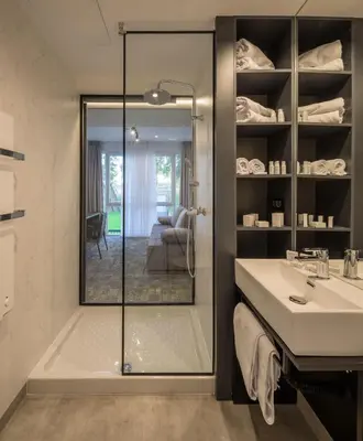 a bathroom with a glass shower and a sink at Joy 5 Hotel & SPA in Belgrade