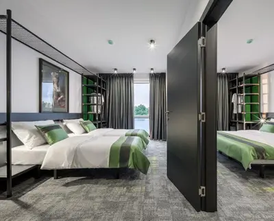 two beds in a bedroom with green and white at Joy 5 Hotel & SPA in Belgrade