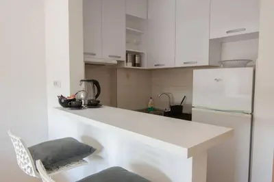 a kitchen with white cabinets and a white refrigerator at A Blok New Modern - Free garage parking, comfortable, quiet with a park view in Belgrade