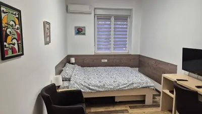a bedroom with a bed and a desk and a television at Cozy apartment in the center of Belgrade - living room, bedroom and bathroom in Belgrade