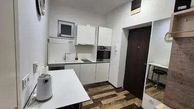 a white kitchen with white cabinets and a table at Cozy apartment in the center of Belgrade - living room, bedroom and bathroom in Belgrade