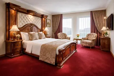 a bedroom with a large bed and a red carpet at Prezident Palace Belgrade - Luxury Boutique Hotel & Spa in Belgrade