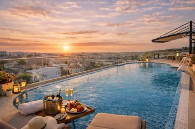a pool on the roof of a building with a sunset at Prezident Palace Belgrade - Luxury Boutique Hotel & Spa in Belgrade