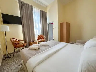 a hotel room with a large bed and two chairs at Vila club 011 in Dedinje