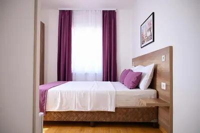 a bedroom with a bed with purple curtains at Dona, Altina in Belgrade
