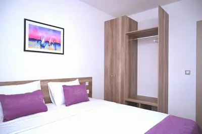 a bedroom with a large bed with purple pillows at Dona, Altina in Belgrade