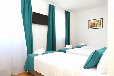 two beds in a room with green curtains at Dona, Altina in Belgrade