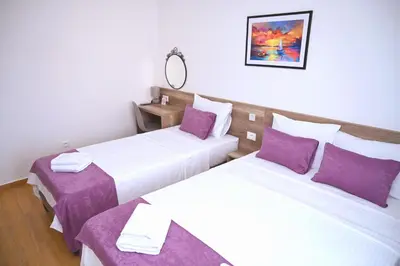 two beds in a hotel room with purple pillows at Dona, Altina in Belgrade