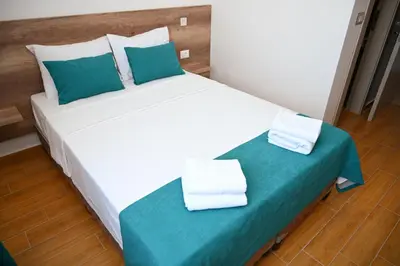 a bedroom with a large white bed with blue pillows at Dona, Altina in Belgrade