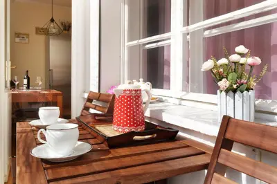 a table with a tea pot and cups and a window at Paradise Starry Suite-City center Belgrade in Belgrade
