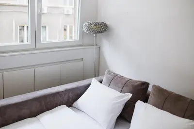 a couch with two pillows and a window at City Center Studio in Belgrade