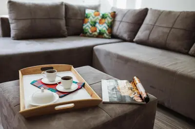 a tray with two cups of coffee and a book on a couch at City Center Studio in Belgrade