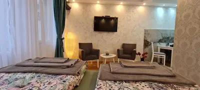 a bedroom with two beds and a television on the wall at OLIVERA APARTMENT in Belgrade