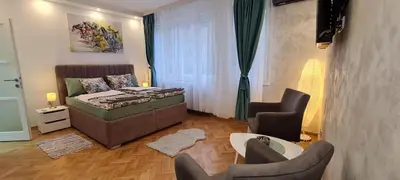 a living room with a couch and a table and chairs at OLIVERA APARTMENT in Belgrade