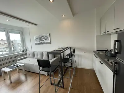 a kitchen and living room with a couch and a table at Apartment Vanilla Belgrade in Belgrade