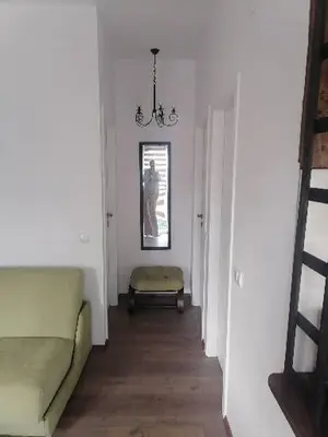a hallway with a couch and a chair in a room at Apartman Garden House in Voždovac