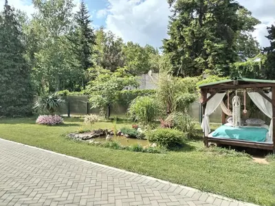a garden with a gazebo and a pond at Apartman Garden House in Voždovac