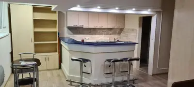 a kitchen with a island with a sink and stools at Le coin de Simon in Belgrade