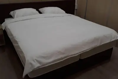a large bed with white sheets and pillows at Le coin de Simon in Belgrade