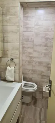a bathroom with a white toilet and a sink at Le coin de Simon in Belgrade