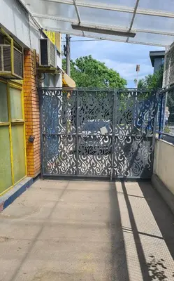 an open gate to a building with a sidewalk at Le coin de Simon in Belgrade
