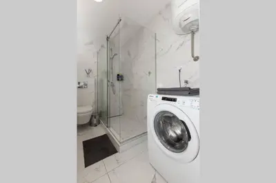 a bathroom with a washing machine and a shower at Zemun Luxury - Comfortable, workspace, quiet, free parking, Netflix in Belgrade