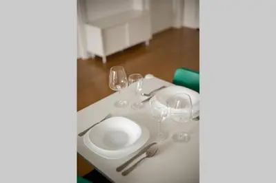 a white table with glasses and a plate on it at Zemun Luxury - Comfortable, workspace, quiet, free parking, Netflix in Belgrade