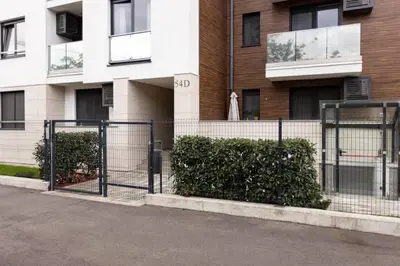 a fence in front of a building with bushes at Zemun Luxury - Comfortable, workspace, quiet, free parking, Netflix in Belgrade