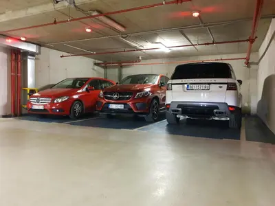 three cars are parked in a garage at Central Park Residence in Belgrade