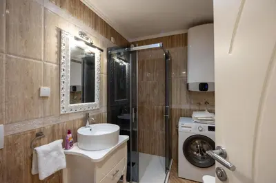 a bathroom with a sink and a washing machine at Belgrade Center Apartment Lux III in Belgrade