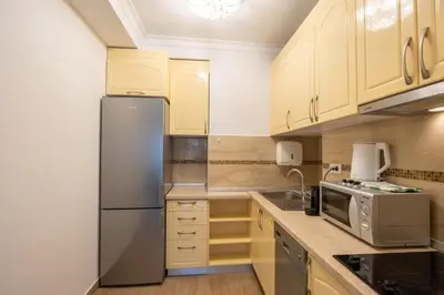 a kitchen with white cabinets and a stainless steel refrigerator at Belgrade Center Apartment Lux III in Belgrade