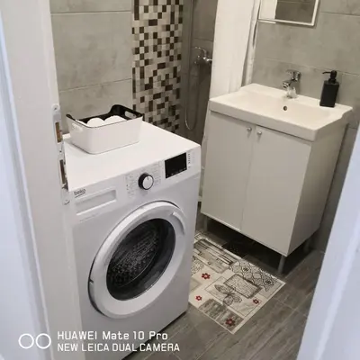 a bathroom with a washing machine and a sink at Bibi's apartment in Belgrade