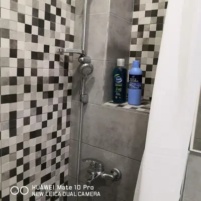 a shower stall with two bottles of water on a tile wall at Bibi's apartment in Belgrade