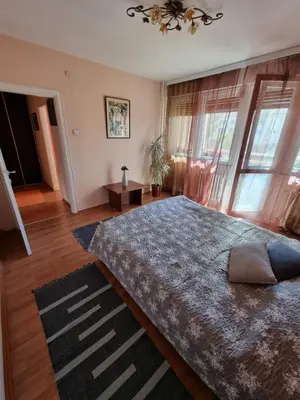 a bedroom with a large bed in a room with windows at Large, Spacious Apartment Voždovac in Belgrade