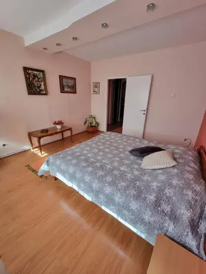 a bedroom with a large bed and a wooden floor at Large, Spacious Apartment Voždovac in Belgrade